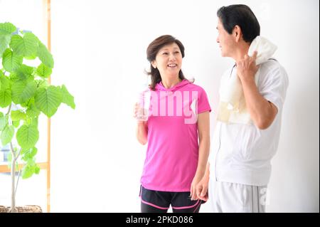 A middle-aged couple taking a break after exercise Stock Photo