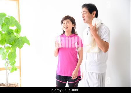 A middle-aged couple taking a break after exercise Stock Photo