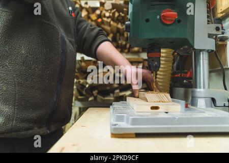 Professional drilling machine in use. Local male carpenter using one of his tools to drill a hole in wooden piece. High quality photo Stock Photo