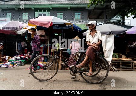 Yangon, Myanmar. 07th Apr, 2023. A trishaw driver sits on their bike in a street market. On February 1, 2021, the military junta government (Tatmadaw) seized power by coup, jailing the democratically-elected NLD (National League for Democracy) government and plunging the country into an ongoing humanitarian crisis, described by many as a civil war or the People's Uprising. (Photo by Matt Hunt/SOPA Images/Sipa USA) Credit: Sipa USA/Alamy Live News Stock Photo