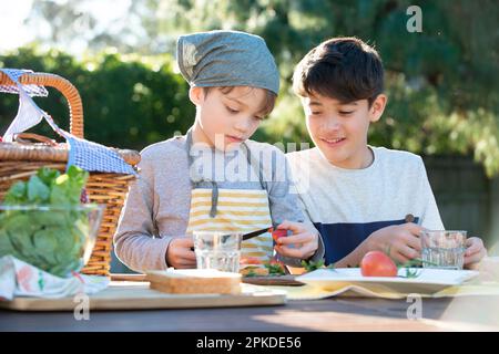 Brothers making sandwiches in the garden Stock Photo