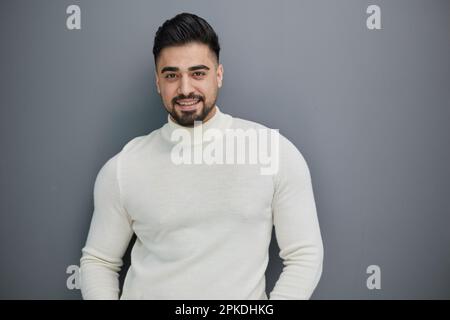 Handsome man in casual sweater looking at camera, positive person. Stock Photo