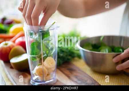 Woman with ingredients for a smoothie in a blender Stock Photo