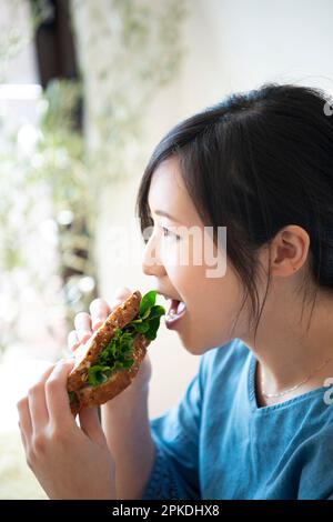 Woman eating a sandwich Stock Photo