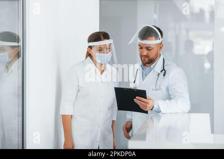 Working with documents. Two doctors in white coats is in the clinic Stock Photo