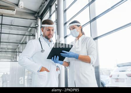 Working with documents. Two doctors in white coats is in the clinic Stock Photo