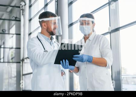 Busy people. Two doctors in white coats is in the clinic working together Stock Photo