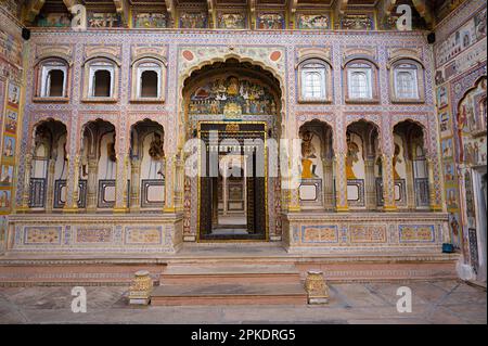 Colourful paintings and carved wooden door of Dr. Ramnath Podar Haveli Museum, a cultural heritage museum which houses Rajasthani living style, miniat Stock Photo