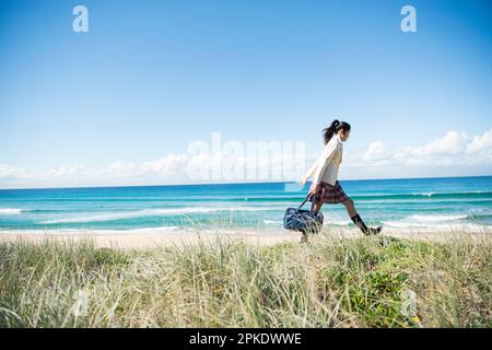 Schoolgirl in school uniform walking Stock Photo - Alamy