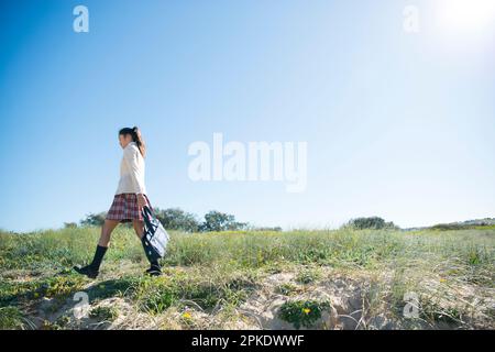 Schoolgirl in school uniform walking Stock Photo - Alamy