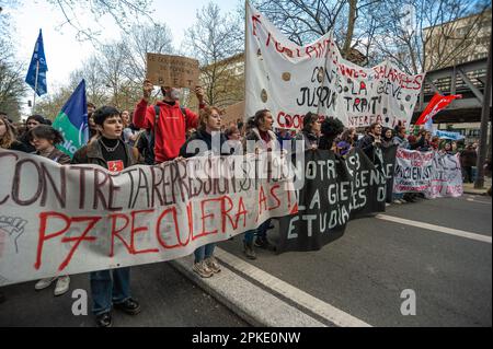 Protesters with banners and flags walk along the Boulevard Raspail during the demonstration. Unions in France, last week called for an 11th day of action for today. They consider ‘the lack of response from the government leads to a situation of tension of great concern” Unions said in a statement, they were calling “for local union rallies and a new big day of strikes and demonstrations throughout the country.” Protesters over the past two-weeks have clashed with police over the French government pension reform policy. President Emmanuel Macron decided to push through the controversial reforms Stock Photo