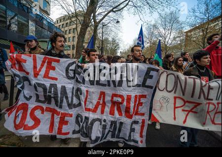 Protesters with banners and flags walk along the Boulevard Raspail during the demonstration. Unions in France, last week called for an 11th day of action for today. They consider ‘the lack of response from the government leads to a situation of tension of great concern” Unions said in a statement, they were calling “for local union rallies and a new big day of strikes and demonstrations throughout the country.” Protesters over the past two-weeks have clashed with police over the French government pension reform policy. President Emmanuel Macron decided to push through the controversial reforms Stock Photo