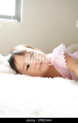 Asian cute baby girl lying on the bed Stock Photo - Alamy