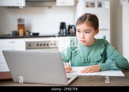 Girl studying at home using computer Stock Photo