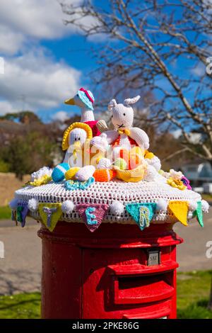 Poole, Dorset, UK. 7th April, 2023. An Easter themed knitted and crocheted postbox topper spreads Easter cheer on a lovely warm sunny Good Friday at the start of the long Easter Bank Holiday weekend.  - post box topper, letterbox topper, letter box topper, toppers, yarn bombing, yarn bomb. Credit: Carolyn Jenkins/Alamy Live News Stock Photo