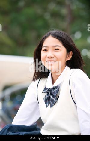 Female student in school uniform looking into the distance and smiling Stock Photo