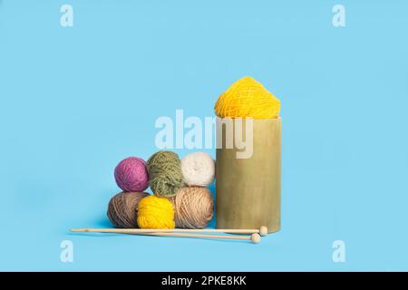 Colored wool balls and knitting needles on a light blue background with copy space Stock Photo