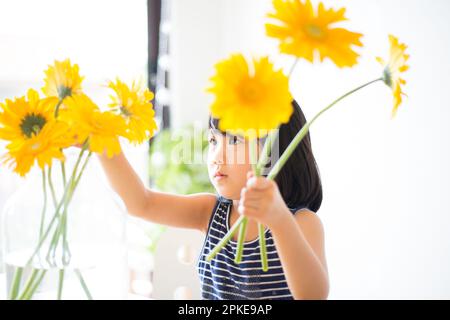 Girl with yellow flowers in a vase Stock Photo