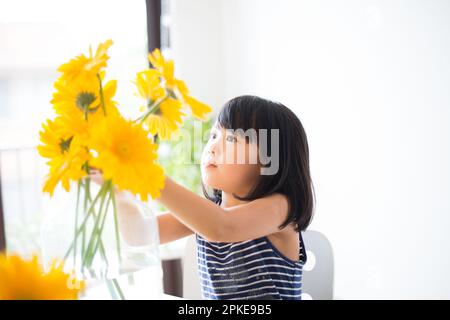 Girl with yellow flowers in a vase Stock Photo