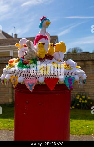 Poole, Dorset, UK. 7th April, 2023. An Easter themed knitted and crocheted postbox topper spreads Easter cheer on a lovely warm sunny Good Friday at the start of the long Easter Bank Holiday weekend.  - post box topper, letterbox topper, letter box topper, toppers, yarn bombing, yarn bomb. Credit: Carolyn Jenkins/Alamy Live News Stock Photo