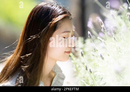 Side profile of a woman smelling lavender Stock Photo