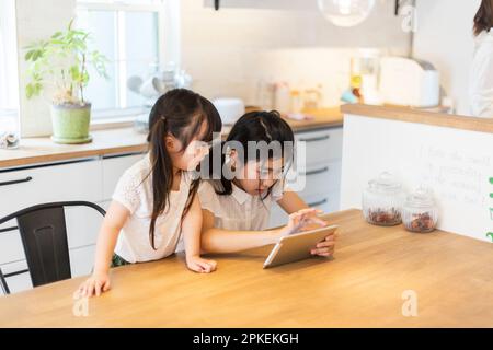 Sisters playing with a tablet Stock Photo