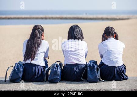 Junior high school students sitting in a line Stock Photo