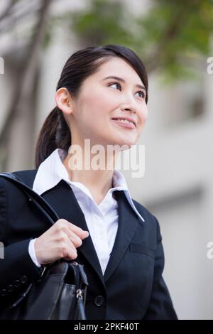 Woman in suit walking in office street Stock Photo
