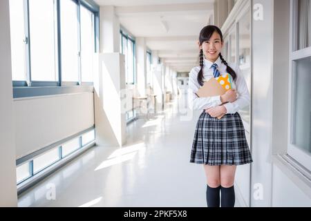 Junior High School Girl Holding a Notebook Stock Photo