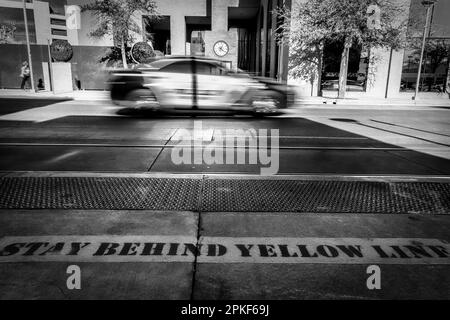 A police car passes a bus stop in the downtown area of El Paso, Texas. Stock Photo