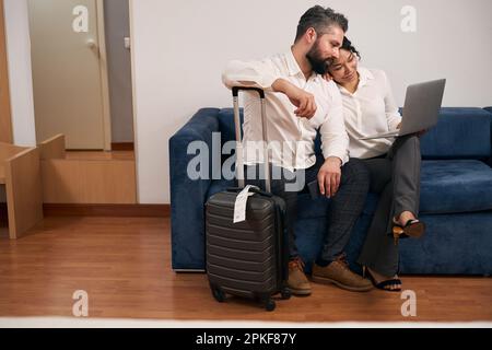 Man and woman using portable computer in hotel room Stock Photo