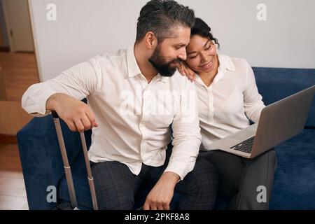 Tourist couple using portable computer in their hotel room Stock Photo