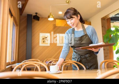 Female waitress clearing a table Stock Photo