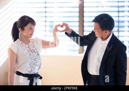 A couple making hearts with their hands Stock Photo