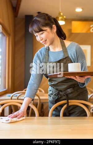 Female waitress clearing a table Stock Photo