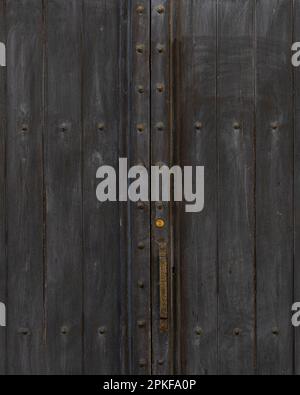 Black double doors with a rusty handle and new lock in Tuscany Stock Photo