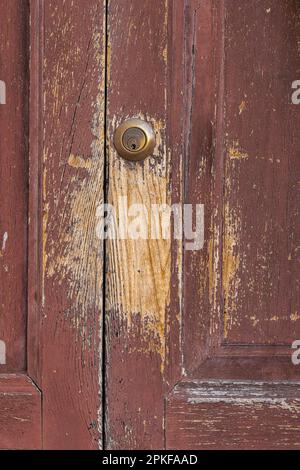 Peeling  red paint on an old wooden door in Tuscany Stock Photo