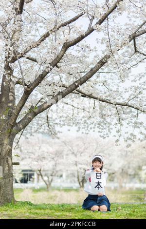 Schoolgirl doing calligraphy under the cherry blossom tree Stock Photo ...