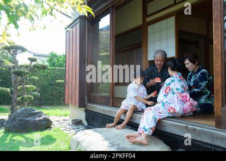 Grandparents and grandchildren eating watermelon on the porch Stock Photo