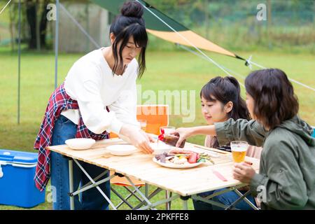 Woman eating at campsite Stock Photo