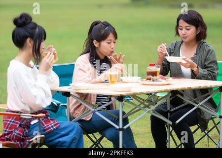 Women eating at a campsite Stock Photo