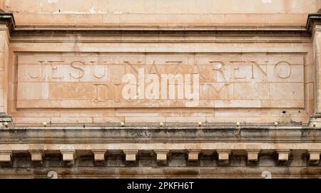 Sliema, Malta - November 12, 2022: Carved dedication text in latin  on Jesus of Nazareth parish Church Stock Photo