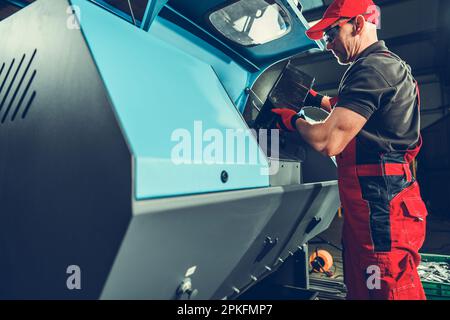 Caucasian Worker in His 40s Operating Metalworking Industry Metal Objects Shaker Cleaning Machinery Stock Photo