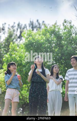 Children and father playing with bubbles at park Stock Photo - Alamy