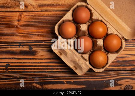 Fresh chicken eggs in cardboard boxes on wooden background Stock Photo