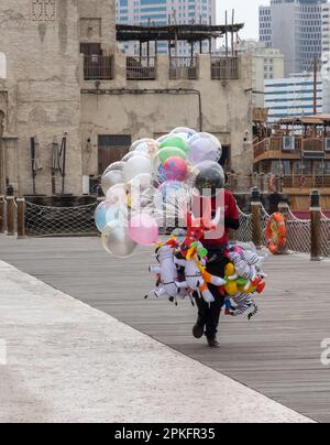 Street trader with balloons and animal toys on Al Seef boardwalk in Dubai, UAE Stock Photo