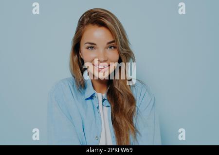 Portrait of attractive young woman with long straight light brown hair, with pretty smile and natural beauty, wears light makeup, dressed in casual sh Stock Photo