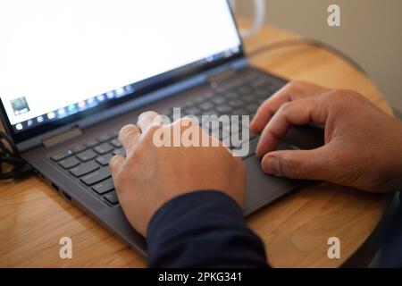Male hands using a laptop, blank screen Stock Photo