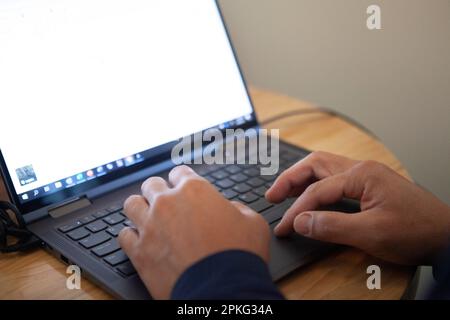 Male hands using a laptop, blank screen Stock Photo