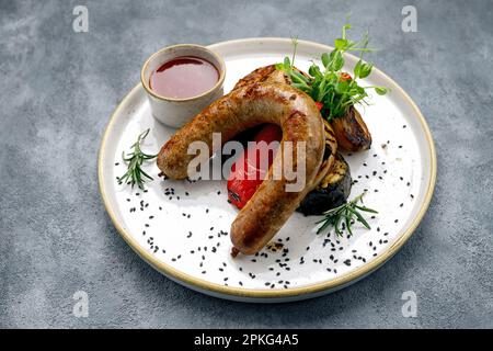 The Perfect BBQ Meal: Grilled Sausages, Veggies, and BBQ Sauce on a Plate Stock Photo